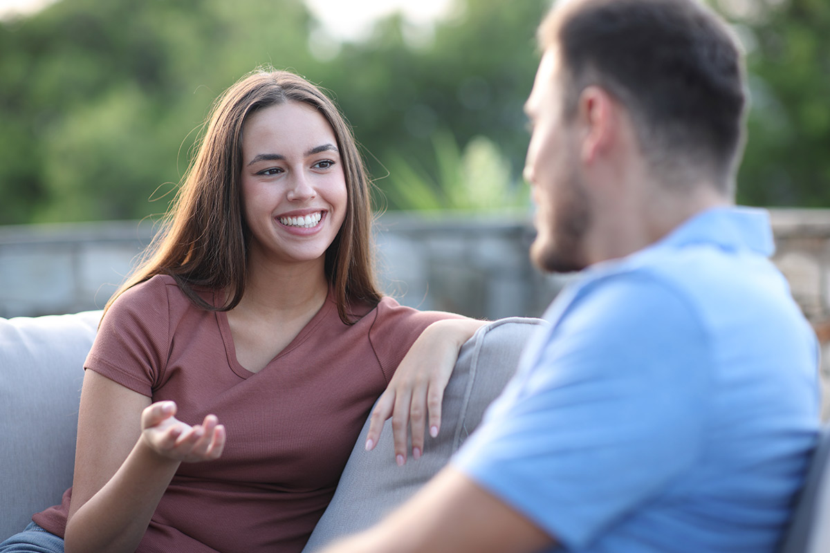 A couple sits together on a couch, discussing ways to foster healthy relationships and heal from past trauma.