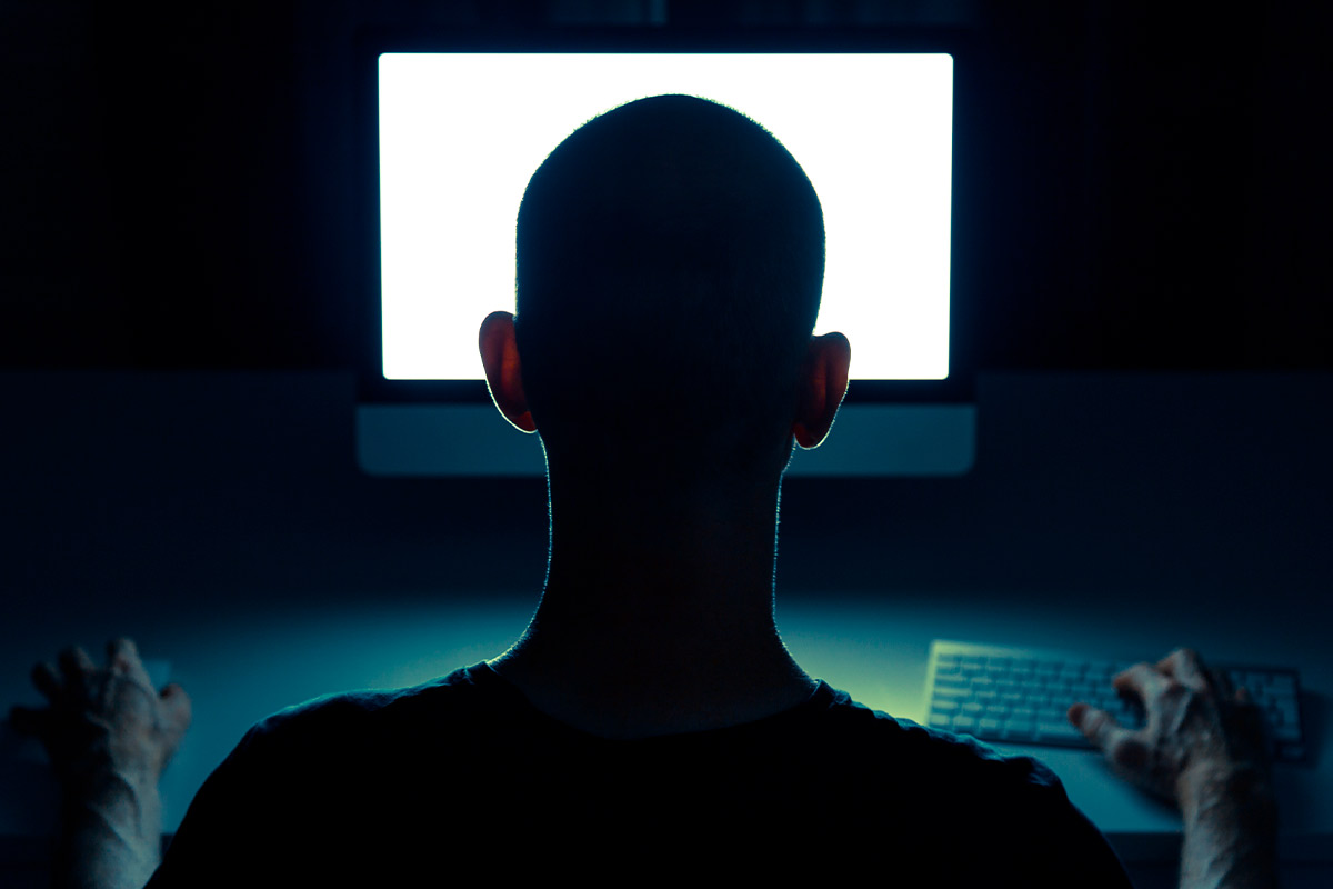 A man engaged with a computer, using a keyboard and mouse, in support of Stalking Awareness Month's safety initiatives.
