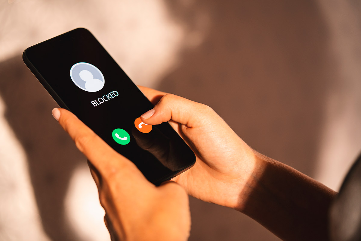 Woman using her phone to call for help, highlighting the need for awareness and safety during Stalking Awareness Month.